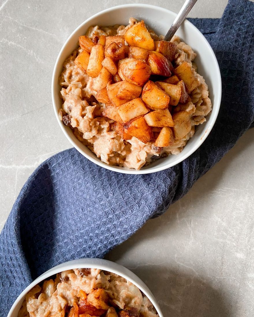 A bowl of oats with cooked apple pieces